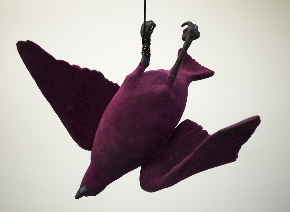 Bird handbuilt from ceramic, surfaced with flocking and graphite, hung with leather cord.